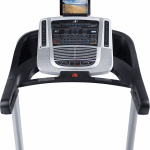 Console of the Nordictrack C 700 Treadmill with a an image of a beach on the tablet. The treadmill includes 2 cup holders, a fan, a speaker, a tablet holder and several buttons