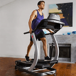 A fit man in athletic attire working out on the Bowflex TC200 TreadClimber in a living room setting